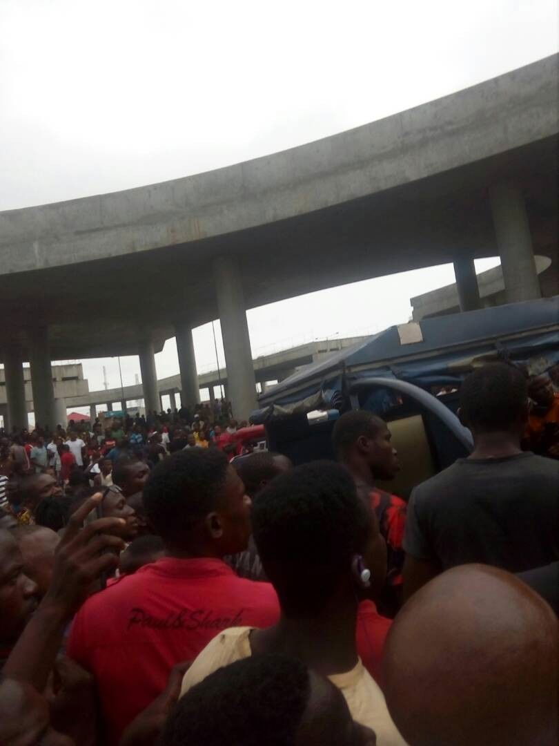 Graphic photos: Armed robber set ablaze after shooting lady dead outside a bank in Lagos