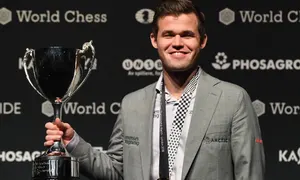 Magnus Carlsen โพสท่ากับถ้วยรางวัลหลังจากชนะแชมป์หมากรุกโลกกับ Fabiano Caruana