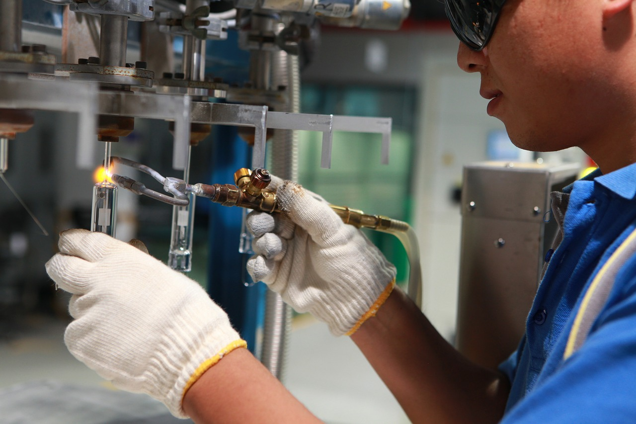 Operaria realizando una reparación en una instalación eléctrica industrial.