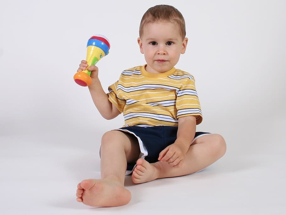 Toddler sitting with a rattle