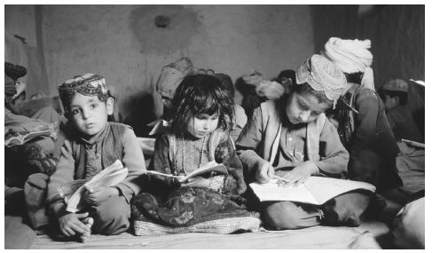 A group of children read in a mosque school in Arghandab, Afghanistan. Although education is valued in Afghanistan, only 5 percent of Afghani children receive a primary education.