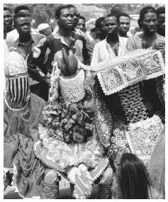 Hooded and masked egunguns are present at a voodoo festival. Egunguns are the ghosts of ancestors, believed to visit earth at certain times of year by possessing living people.