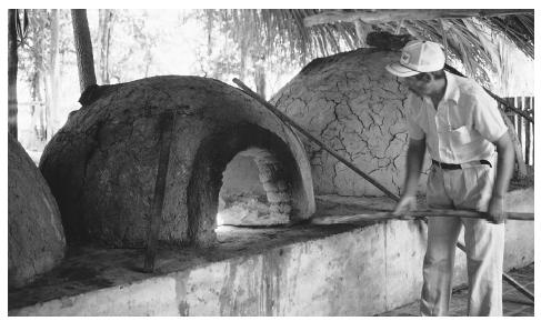 A man puts bread in the oven in a farm on the Rio Guapay near Santa Cruz. A typical Bolivian diet is high in carbohydrates.