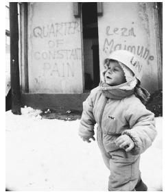 A child playing while wearing a United Nations helmet. Many schools were closed during the war, leaving children with no access to education.