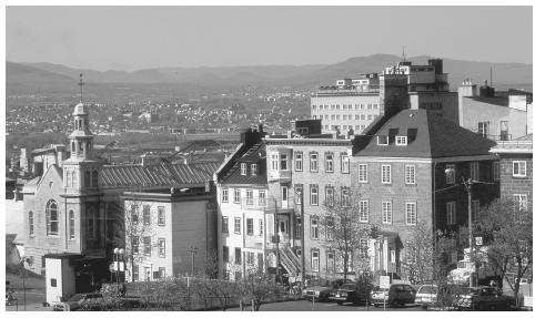 A church and townhouses line a street, with Quebec City, Quebec, behind them.