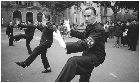 A group of people practice tai chi along the main thoroughfare in Shanghai. The popular form of exercise emphasizes slow, graceful movements.