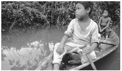 Two boys in a canoe on the bank of the Amazon River, near San Martin. The Amazonian basin is home to several indigenous populations.