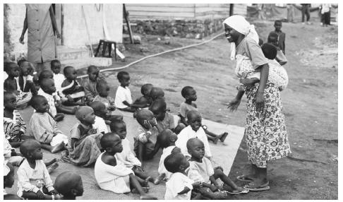 Young Rwandan refugees sit on a blanket outside an orphanage in Goma, Democratic Republic of the Congo.