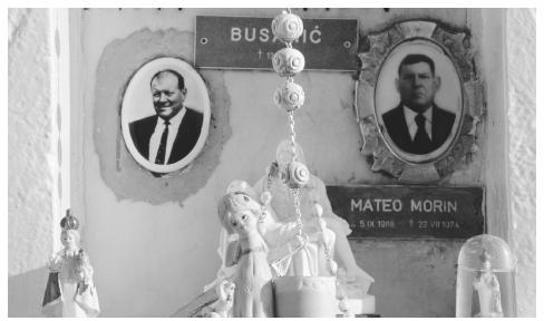 Photos decorate a family grave within a cemetery on the island of Susak. It is common in Croatia to decorate graves with candles, flowers, and photos.