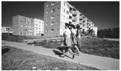 A group of women walk past apartments in Havana. Housing is at a premium in Havana, and it is not uncommon for families to share an apartment.