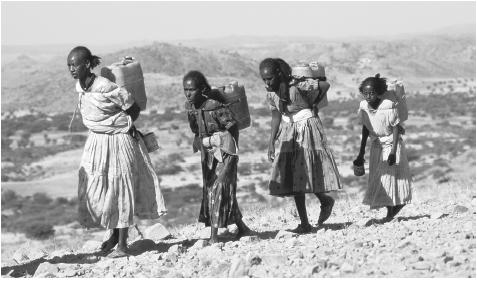 Women carrying water from a river two hours away from their homes in Adi Baren, Akeleguzay.