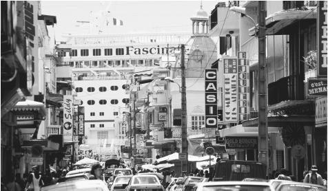 A cruise ship docked at the end of a crowded street in Pointe-á-Pitre, Guadeloupe.