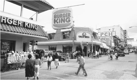 People walk past fast-food restaurants in Guatemala City, Guatemala. "Fast food" is a fairly recent addition to traditional Guatemalan diets.