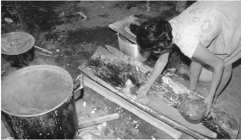 A woman prepares cachiri, an alcoholic drink, in a workshop.