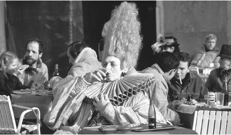 A man in elaborate costume at an outside café celebrates during the Venice Carnival in Piazza San Marco, Venice.