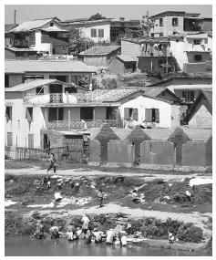 Washing clothes in the Ikopa River, Antananarivo. Men and women share responsibility for domestic tasks, although women often manage meal preparation, shopping, and laundry.