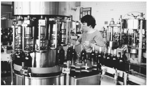 A worker supervising bottling at a winery in Chisinau. Wine is a symbolic drink used to honor the host at a meal.