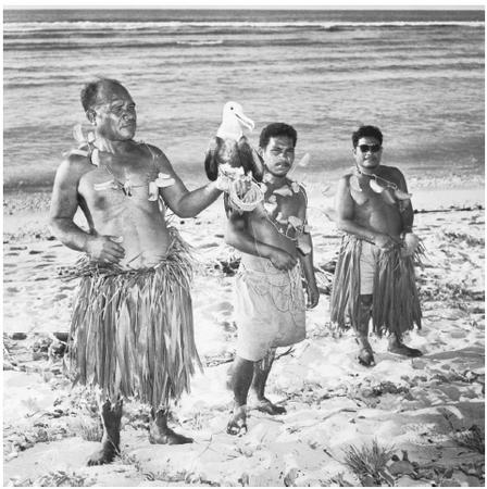 Islanders with a tame frigate bird for catching fish. Almost all food is imported, with the exception of fish.