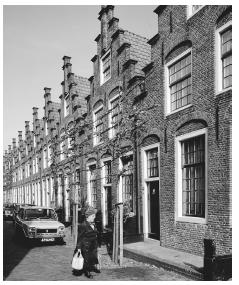 Brick row houses in Haarlem have prominent front doors and large windows.