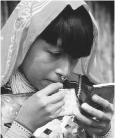 A Kuna woman applies paint to her face in the San Blas Islands. Four Indian ethnic groups are officially recognized, including the Kuna.