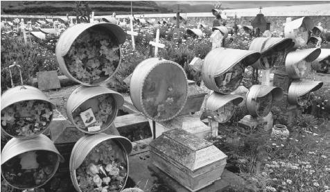 Portraits of the deceased ornament their grave markers in an Azorean cemetery.