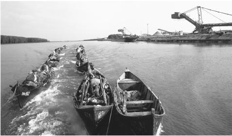 Fishermen in boats on the Danube near a fishing village. All fishermen officially work for the state, though they survive by selling 70 percent of their catch on the black market.