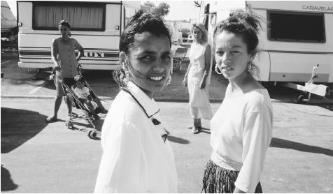 Roma women standing near their motor homes. Many Roma are not culturally assimilated into modern Romanian culture.