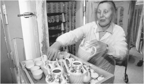 A woman places teapots and teacups in a cabinet, possibly for drying, at the Lomonosov Porcelain Factory. Unemployment for women has increased in the 1990s, especially in the manufacturing sector.