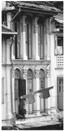 Shutters open out onto clotheslines in downtown colonial-style housing in Singapore.