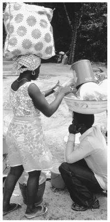 Carrying bundles balanced on the head is common in Djuka villages in Suriname.