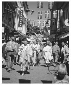 Pedestrians walk down a busy street in a shopping district in Göteborg.