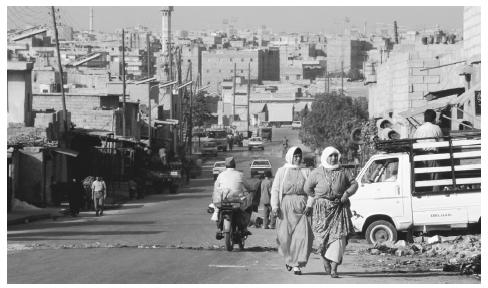 People walking along a street in Aleppo, the nation's second largest city. Protected by rocky terrain, Aleppo was once a fort.