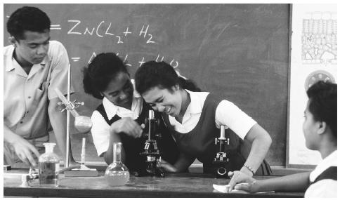 Tongan students use microscopes as part of a science experiment. Tonga has an almost universal rate of literacy.