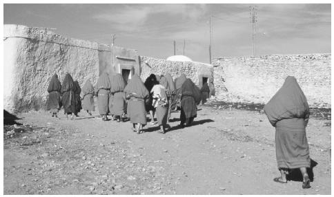 Tunisian mourners wear traditional bright red costumes at funerals. Corpses are laid on the left side, facing Mecca.