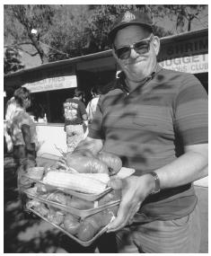 A man holds trays of cooked lobster and corn on the cob at the annual Yarmouth Clam Festival in Yarmouth, Maine.