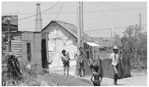 Simple homes with a flaring oil well in the background, Cabimas. Oil is Venezuela's most profitable export product.