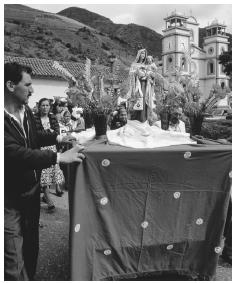 Parishioners push a portable shrine past a church during a festival. Most Venezuelans practice Catholicism.