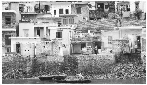 Houses clustered along the shore of Halong Bay. It is common for houses in Vietnam to be built close to one another within a village.