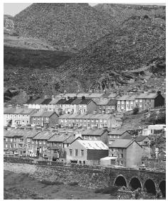 A pile of slate rests above a Welsh town. Mining is an important industry in Wales.