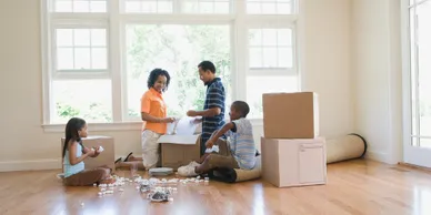 Happy family unpacking in newly moved in home.