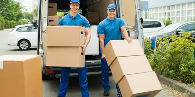 Two men unpacking shuttle service vehicle for home or office removal.