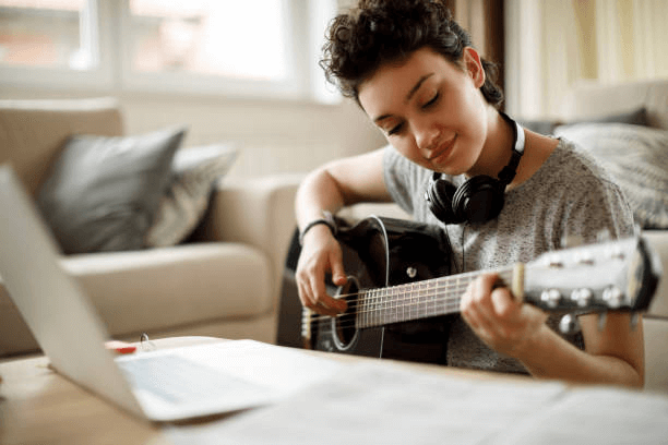 jeune fille souriante, jouer de la guitare à la maison - musicien photos et images de collection