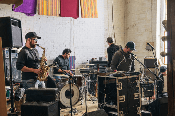 band practicing with musical instruments in recording studio - musicien photos et images de collection