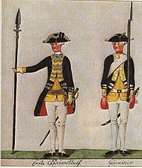 Portrait of two Hessian auxiliaries deployed in America in their uniforms; one with an upright pike formally at “dress right”, one with a musket formally at “left carry arms”.