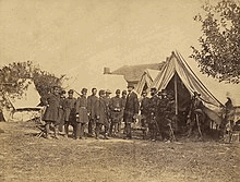 Lincoln among a group of soldiers in a military camp