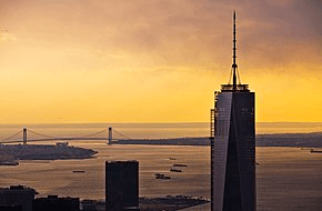 One World Trade Center seen at sunset; the Verrazzano-Narrows Bridge is in the background