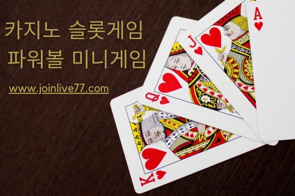 A brown table place a king, queen, jack, and ace heart cards