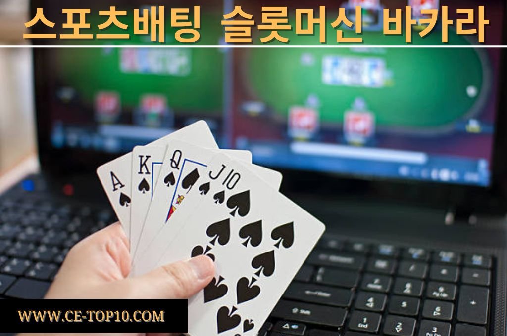 Hand holding Royal Flush cards in front of laptop