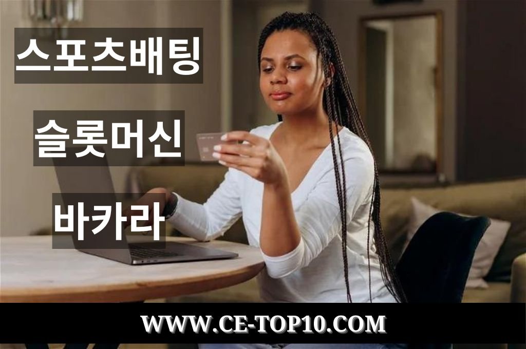 Beautiful woman looking in the laptop while holding mastercard for online casino.